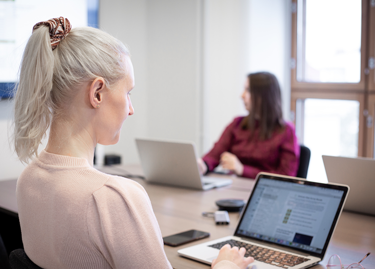 A person sending transactional emails on a laptop