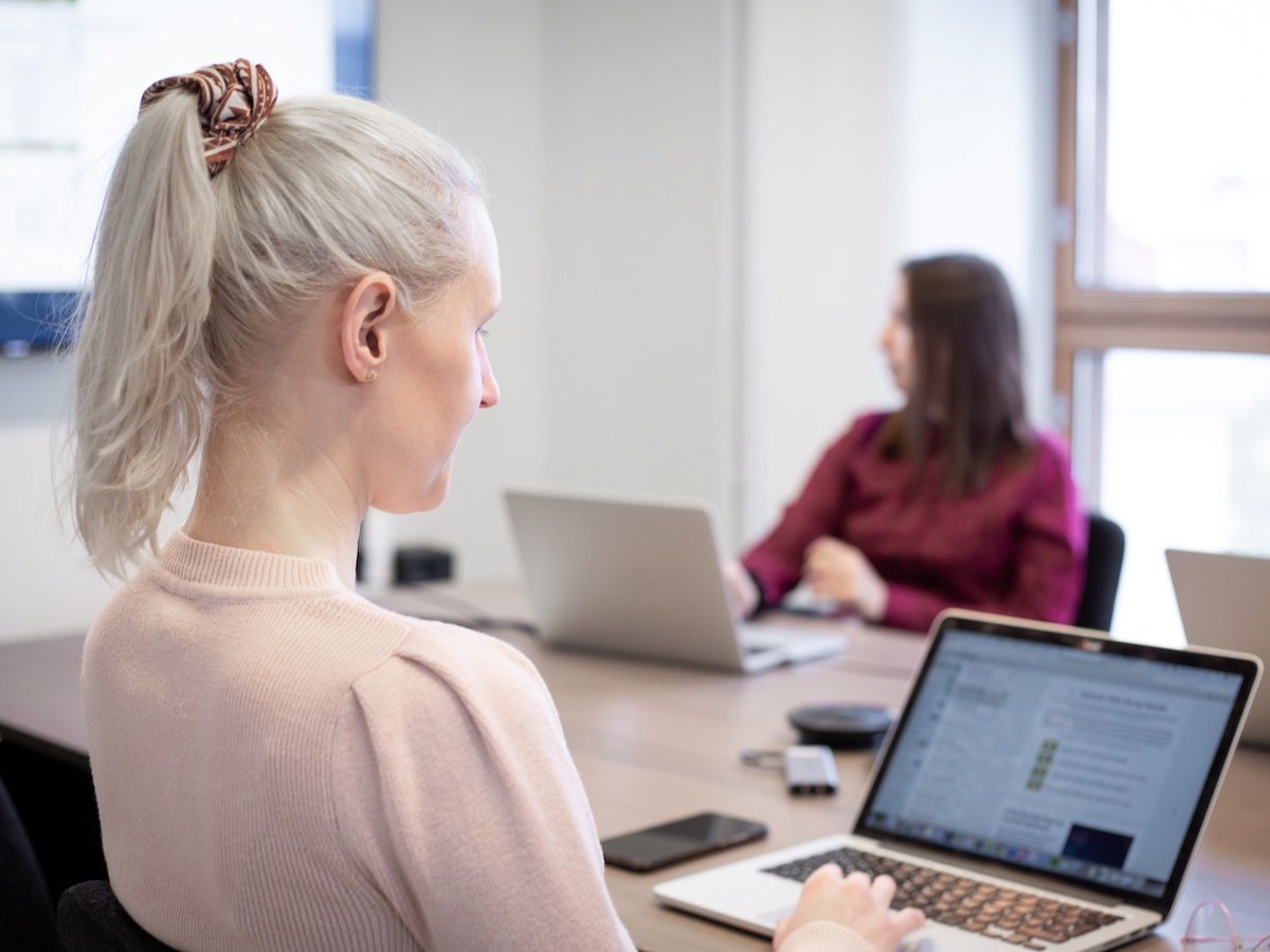 A person sending transactional emails on a laptop