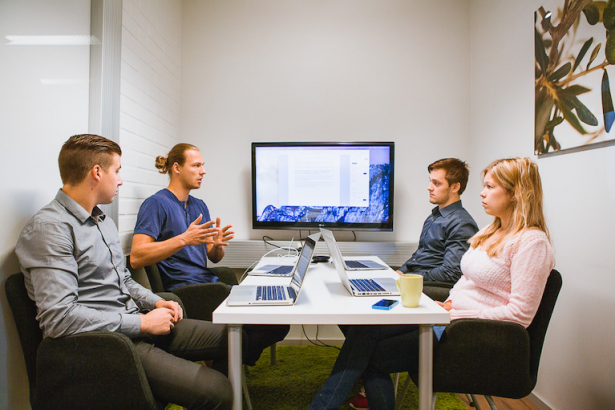 People meeting in a room and working with Liana media analyses