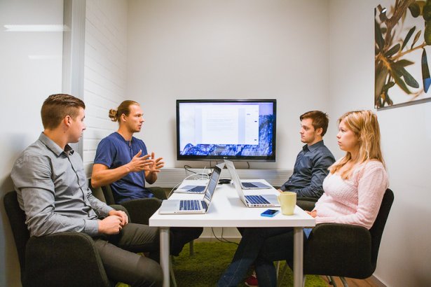 People meeting in a room and working with Liana media analyses